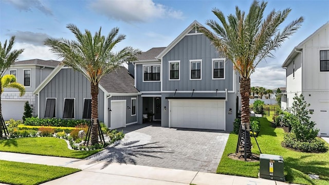 9352 Santorini Dr, Orlando, FL 32827 - view of front of property featuring board and batten siding, decorative driveway, an attached garage, and a front yard