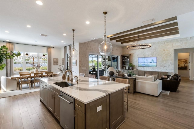 9352 Santorini Dr, Orlando, FL 32827 - kitchen with stainless steel dishwasher, wood finished floors, recessed lighting, open floor plan, and light stone countertops