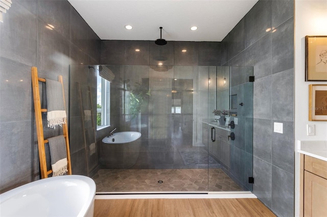 9352 Santorini Dr, Orlando, FL 32827 - full bathroom featuring a stall shower, wood finished floors, a freestanding bath, tile walls, and recessed lighting