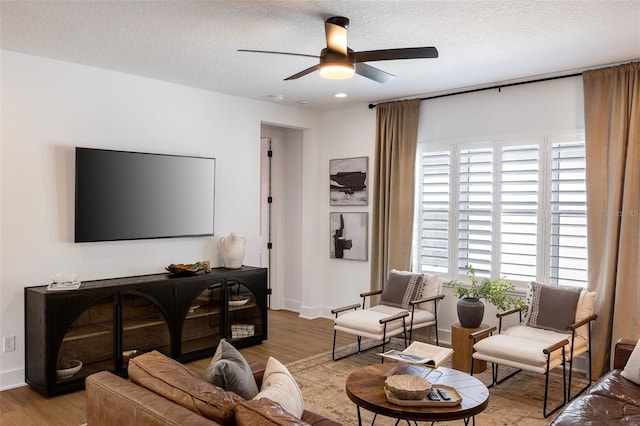 9352 Santorini Dr, Orlando, FL 32827 - living area featuring wood finished floors, a ceiling fan, and a textured ceiling