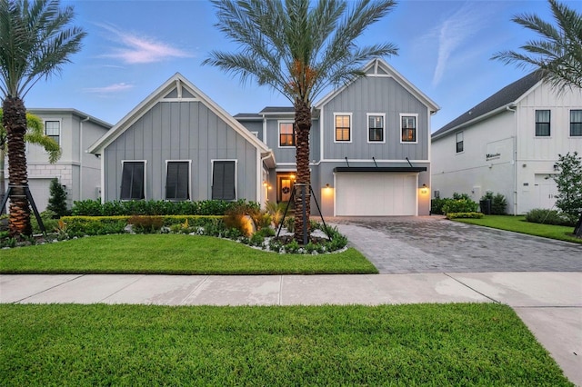 9352 Santorini Dr, Orlando, FL 32827 - modern inspired farmhouse featuring board and batten siding, decorative driveway, a garage, and a front yard