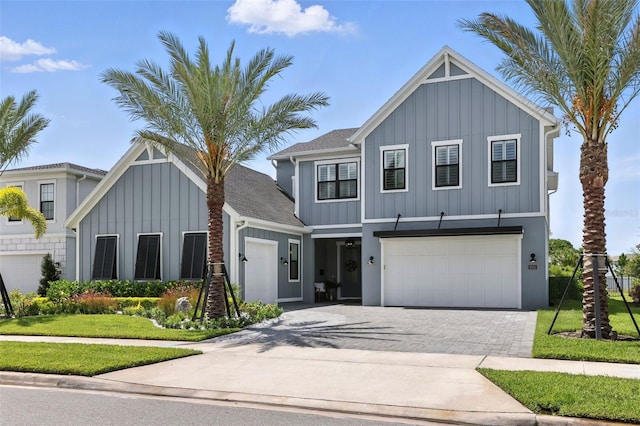 9352 Santorini Dr, Orlando, FL 32827 - view of front of house with board and batten siding, driveway, a garage, and a front yard