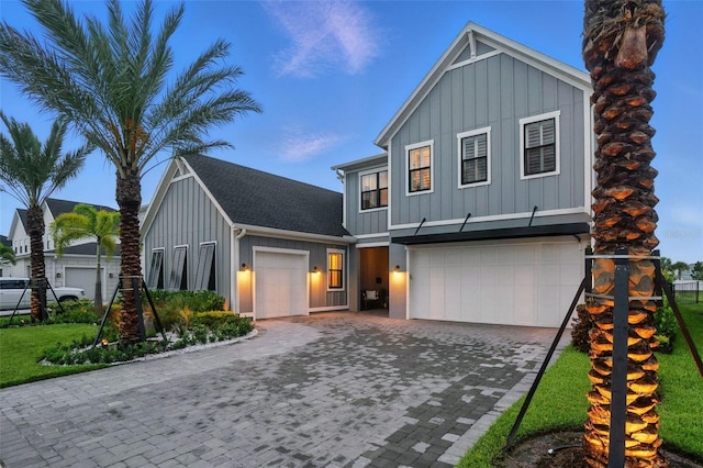 9352 Santorini Dr, Orlando, FL 32827 - view of front of property featuring board and batten siding, decorative driveway, and an attached garage