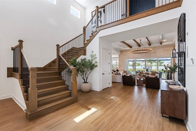 9352 Santorini Dr, Orlando, FL 32827 - stairs featuring a high ceiling, wood finished floors, beamed ceiling, and a chandelier