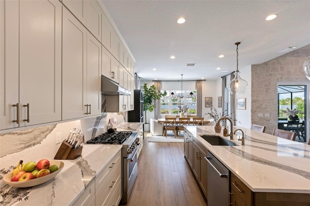 9352 Santorini Dr, Orlando, FL 32827 - kitchen with stainless steel appliances, under cabinet range hood, recessed lighting, dark wood-style floors, and a large island with sink