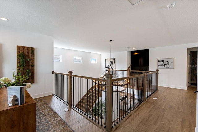9352 Santorini Dr, Orlando, FL 32827 - hallway featuring an upstairs landing, wood finished floors, and recessed lighting