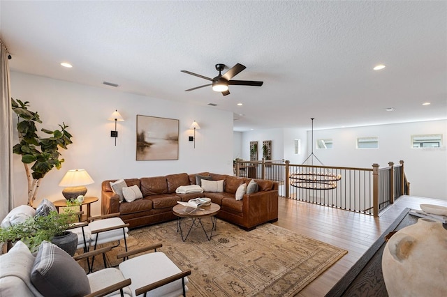 9352 Santorini Dr, Orlando, FL 32827 - living room featuring a ceiling fan, healthy amount of natural light, light wood finished floors, recessed lighting, and a textured ceiling