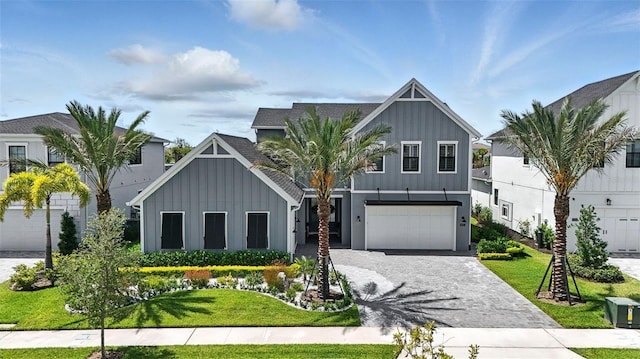 9352 Santorini Dr, Orlando, FL 32827 - view of front facade with board and batten siding, decorative driveway, a front yard, and an attached garage