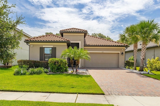 3837 Carrick Bend Dr, Kissimmee, FL 34746 - mediterranean / spanish-style house featuring an attached garage, driveway, a front yard, stucco siding, and a tiled roof
