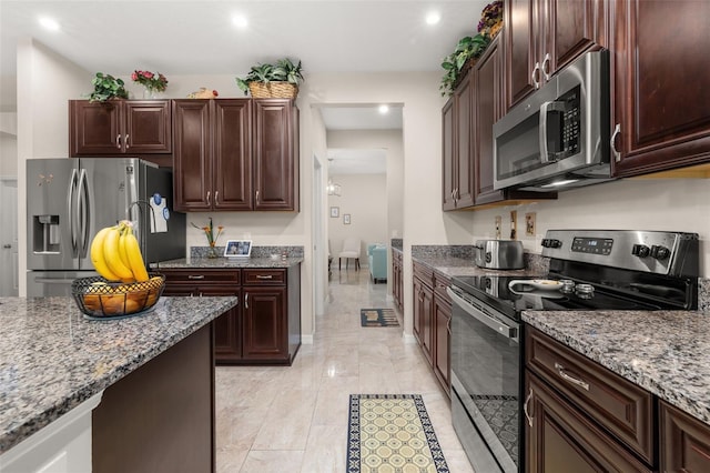 3837 Carrick Bend Dr, Kissimmee, FL 34746 - kitchen featuring appliances with stainless steel finishes, dark stone counters, recessed lighting, light marble finish flooring, and dark brown cabinets