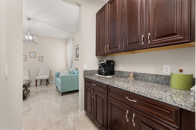 3837 Carrick Bend Dr, Kissimmee, FL 34746 - kitchen featuring light stone counters, light marble finish flooring, open floor plan, and dark brown cabinetry
