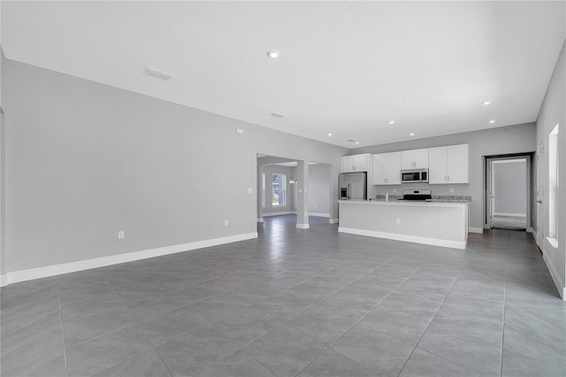 547 Viceroy Ct, Kissimmee, FL 34758 - unfurnished living room with light tile patterned flooring and recessed lighting