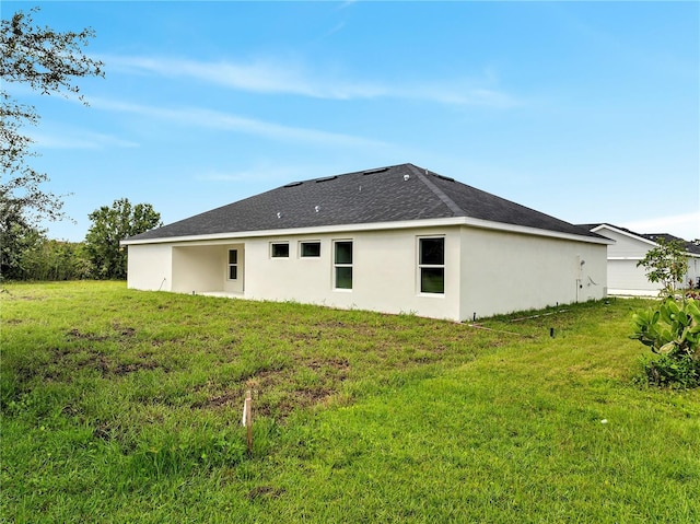 547 Viceroy Ct, Kissimmee, FL 34758 - rear view of property with a yard, stucco siding, and a shingled roof