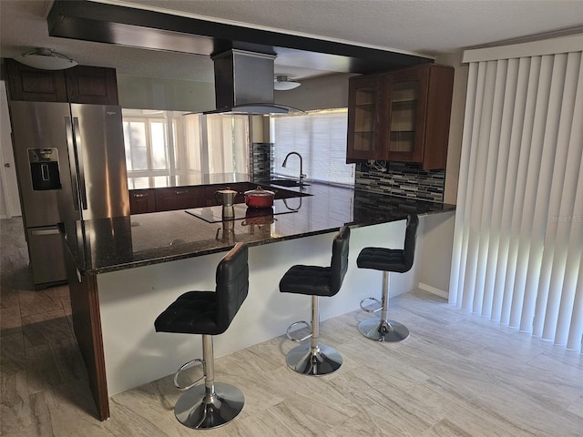 12215 Cobble Stone Dr, Hudson, FL 34667 - kitchen featuring stainless steel fridge with ice dispenser, glass insert cabinets, a kitchen breakfast bar, and a peninsula