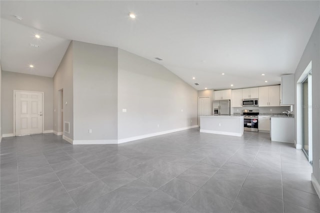 549 Viceroy Ct, Kissimmee, FL 34758 - unfurnished living room featuring lofted ceiling, recessed lighting, and light tile patterned floors