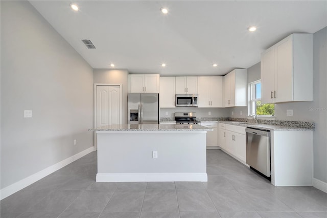 549 Viceroy Ct, Kissimmee, FL 34758 - kitchen with appliances with stainless steel finishes, a center island, white cabinets, light stone counters, and recessed lighting