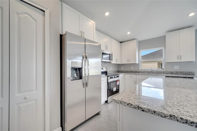 549 Viceroy Ct, Kissimmee, FL 34758 - kitchen featuring appliances with stainless steel finishes, white cabinetry, light stone counters, recessed lighting, and light tile patterned floors