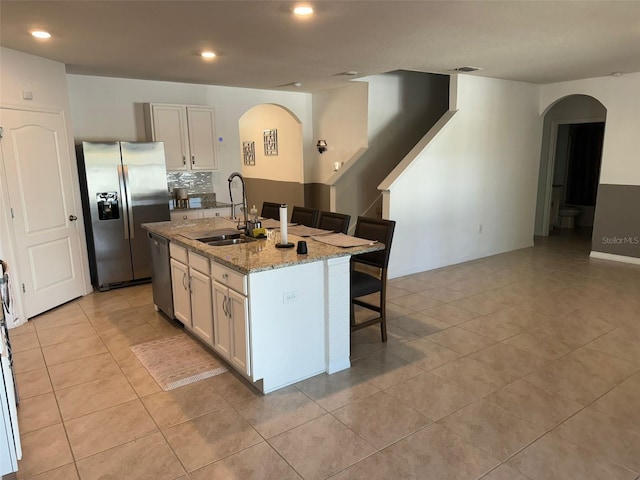 636 Autumn Stream Drive St, Auburndale, FL 33823 - kitchen featuring appliances with stainless steel finishes, arched walkways, a breakfast bar area, light stone countertops, and recessed lighting