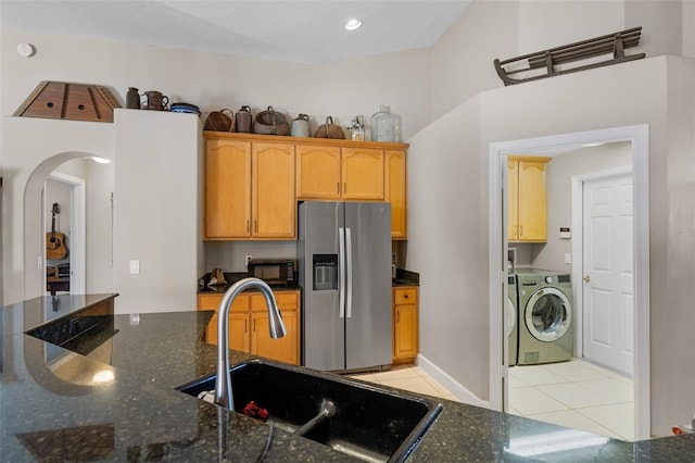 1525 Gants Cir, Kissimmee, FL 34744 - kitchen featuring stainless steel fridge with ice dispenser, washer / dryer, light tile patterned flooring, arched walkways, and black microwave