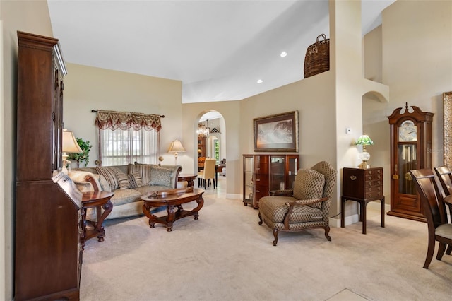 1525 Gants Cir, Kissimmee, FL 34744 - living room featuring arched walkways, light carpet, a chandelier, recessed lighting, and a high ceiling