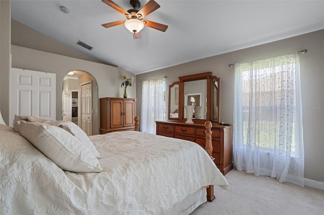 1525 Gants Cir, Kissimmee, FL 34744 - bedroom featuring arched walkways, vaulted ceiling, light carpet, and a ceiling fan