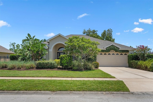 1525 Gants Cir, Kissimmee, FL 34744 - view of front of home with an attached garage, concrete driveway, and stucco siding