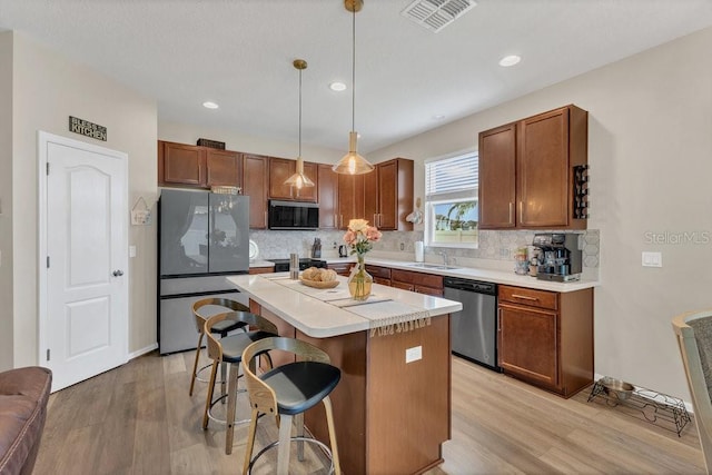 1864 Castleton Dr, Saint Cloud, FL 34771 - kitchen with stainless steel appliances, light wood-style flooring, tasteful backsplash, light countertops, and recessed lighting