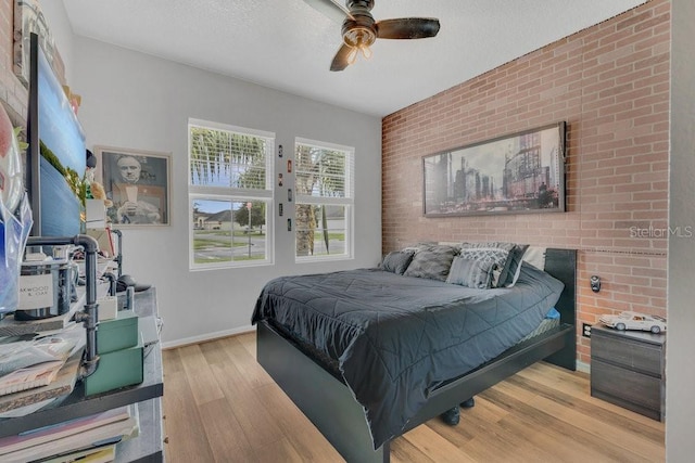 1864 Castleton Dr, Saint Cloud, FL 34771 - bedroom featuring brick wall, light wood-style flooring, an accent wall, and ceiling fan