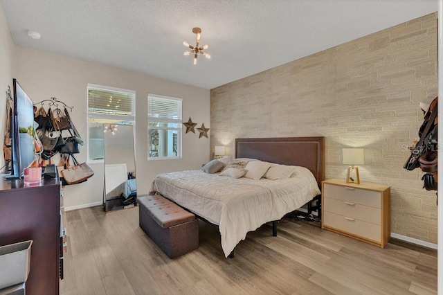 1864 Castleton Dr, Saint Cloud, FL 34771 - bedroom with a chandelier, light wood-style flooring, and an accent wall