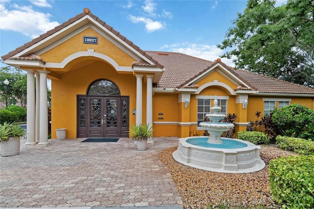 8836 Villa View Cir Unit 303, Orlando, FL 32821 - property entrance with french doors, a tiled roof, and stucco siding