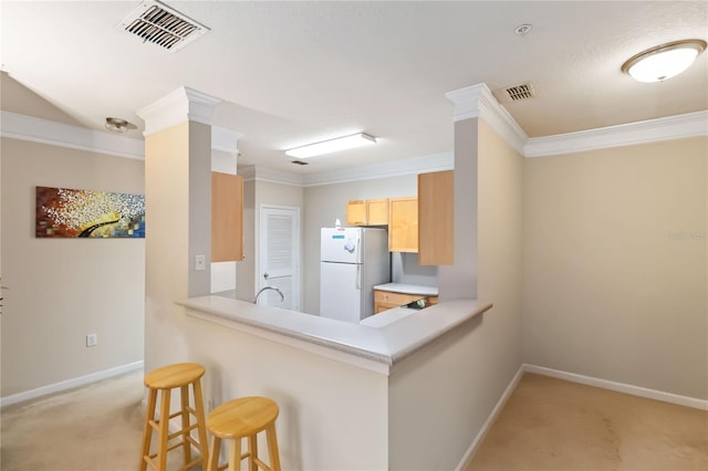 8836 Villa View Cir Unit 303, Orlando, FL 32821 - kitchen with freestanding refrigerator, light carpet, a kitchen bar, a peninsula, and ornamental molding