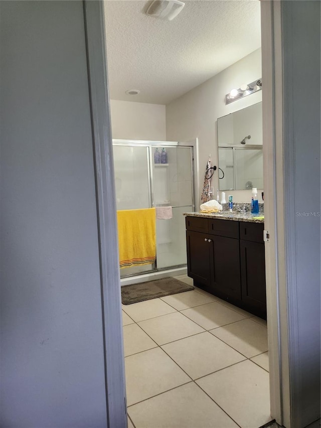 144 Hawthorne Way, Davenport, FL 33896 - bathroom with a stall shower, a textured ceiling, vanity, and tile patterned floors