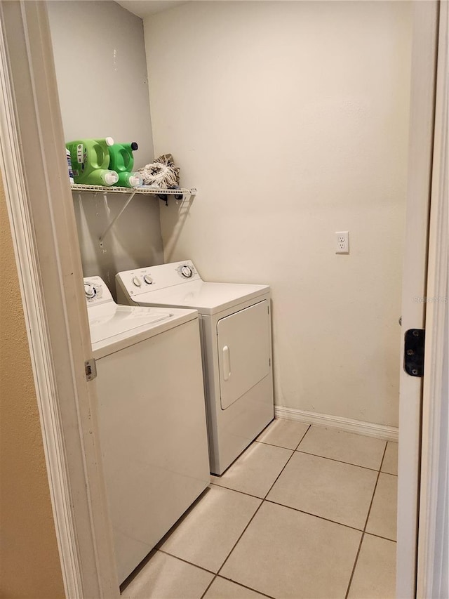 144 Hawthorne Way, Davenport, FL 33896 - laundry room featuring washing machine and dryer and light tile patterned floors