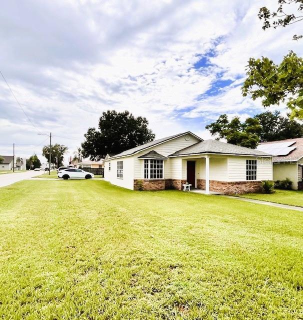 812 10th St, Saint Cloud, FL 34769 - view of front of property featuring a front lawn and brick siding