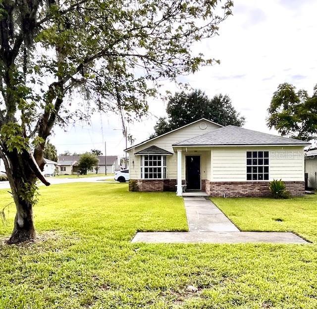 812 10th St, Saint Cloud, FL 34769 - view of front of property featuring a front yard and brick siding