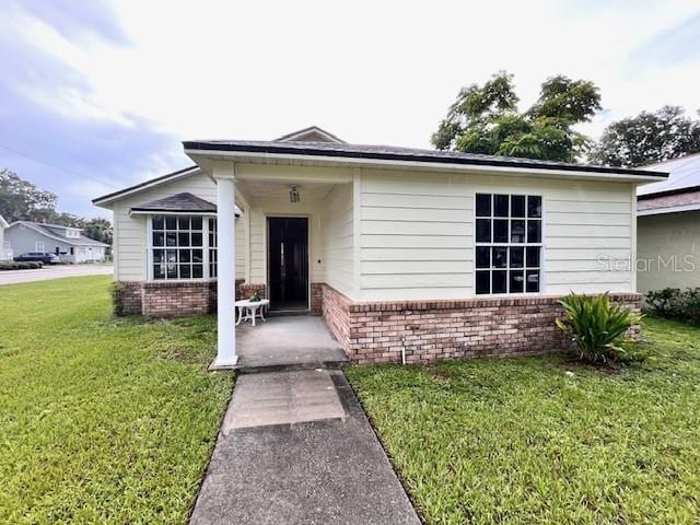812 10th St, Saint Cloud, FL 34769 - view of front facade with brick siding and a front yard