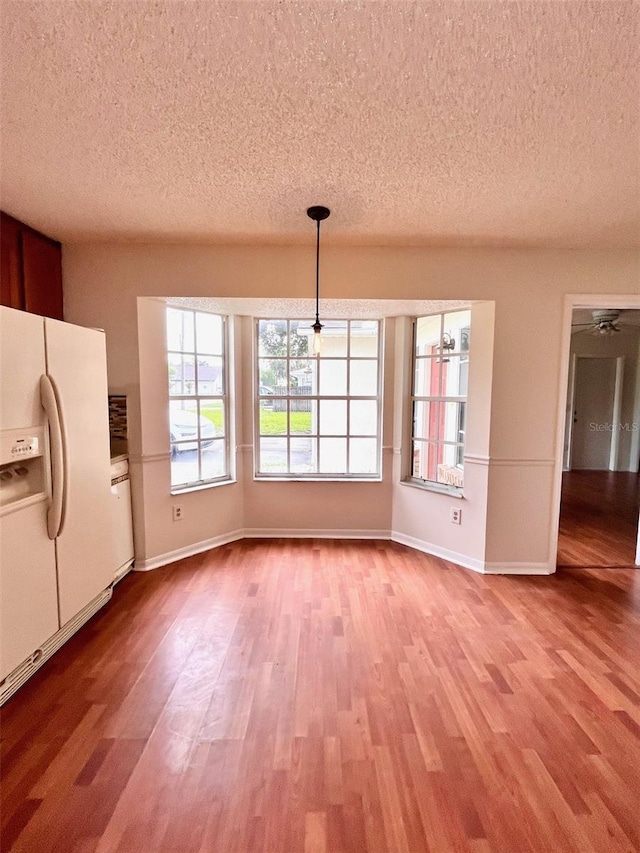 812 10th St, Saint Cloud, FL 34769 - unfurnished dining area featuring a textured ceiling and wood finished floors