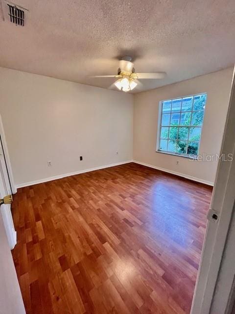 812 10th St, Saint Cloud, FL 34769 - spare room with dark wood finished floors, a ceiling fan, and a textured ceiling