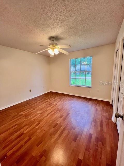 812 10th St, Saint Cloud, FL 34769 - unfurnished bedroom featuring dark wood-style flooring, a textured ceiling, and a ceiling fan