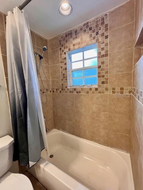 812 10th St, Saint Cloud, FL 34769 - bathroom featuring toilet and shower / bath combo with shower curtain