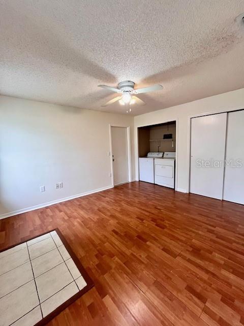 812 10th St, Saint Cloud, FL 34769 - unfurnished bedroom with separate washer and dryer, two closets, wood finished floors, a textured ceiling, and a ceiling fan