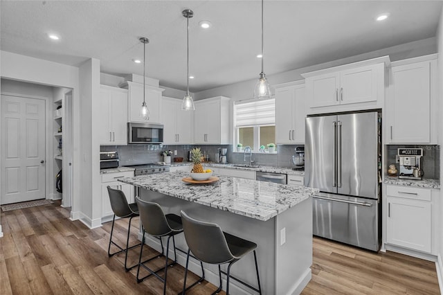 3252 Jackson Bluff Way, Clermont, FL 34711 - kitchen featuring stainless steel appliances, a kitchen breakfast bar, white cabinetry, a center island, and recessed lighting