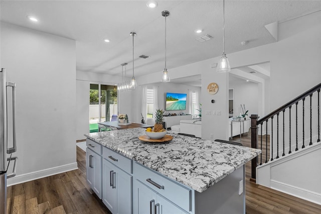 3252 Jackson Bluff Way, Clermont, FL 34711 - kitchen with light stone countertops, dark wood-type flooring, a center island, hanging light fixtures, and recessed lighting