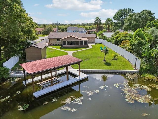 27805 Lois Dr, Tavares, FL 32778 - rear view of property featuring a storage shed, a fenced backyard, a water view, a sunroom, and boat lift
