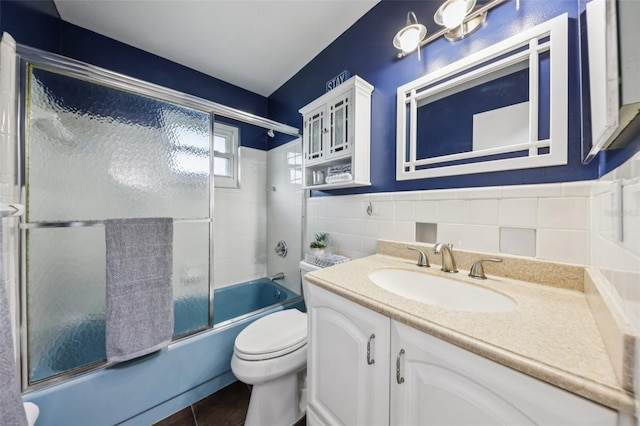 27805 Lois Dr, Tavares, FL 32778 - full bath with vanity, bath / shower combo with glass door, tile walls, and wainscoting