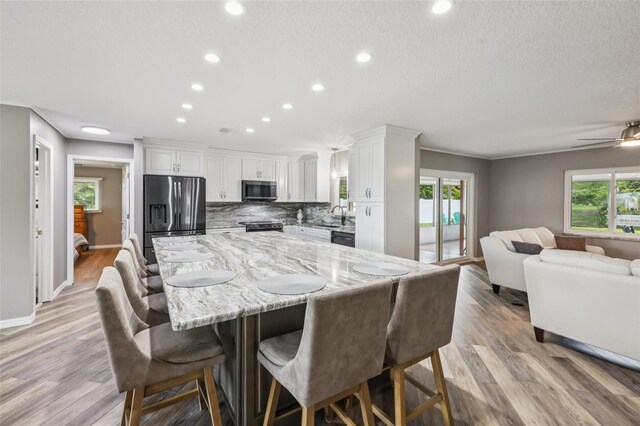 27805 Lois Dr, Tavares, FL 32778 - dining space with recessed lighting, healthy amount of natural light, light wood-style flooring, a textured ceiling, and a ceiling fan