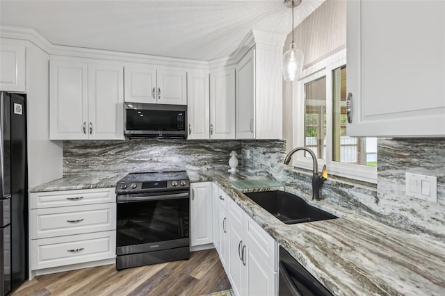 27805 Lois Dr, Tavares, FL 32778 - kitchen with stainless steel appliances, light stone countertops, white cabinets, and backsplash