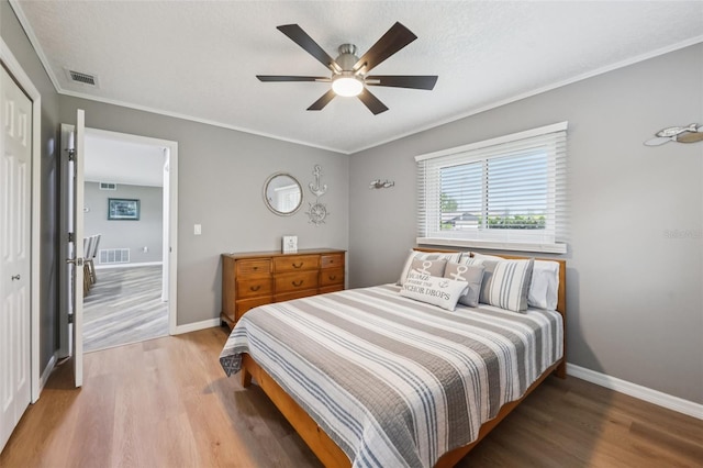 27805 Lois Dr, Tavares, FL 32778 - bedroom with wood finished floors, crown molding, a ceiling fan, and a closet