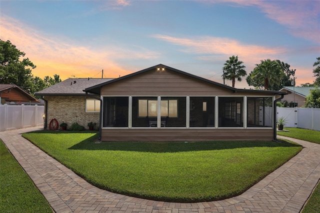 27805 Lois Dr, Tavares, FL 32778 - back of property featuring a sunroom, a fenced backyard, and brick siding