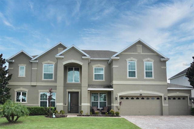 16004 Ollivett St, Winter Garden, FL 34787 - view of front facade featuring stucco siding, a front yard, decorative driveway, and a garage